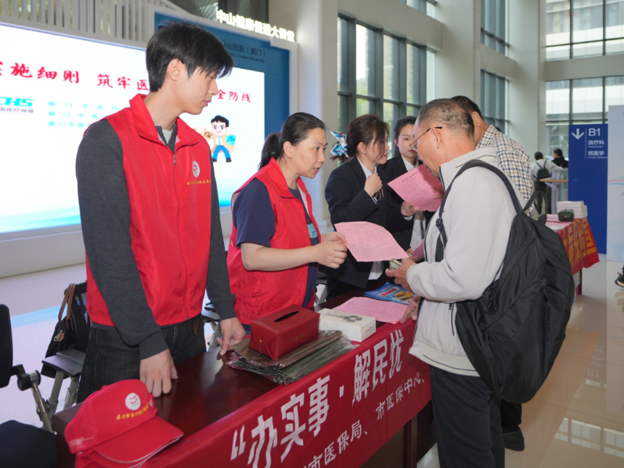 工作人员向市民发放宣传材料。厦门市医保局供图