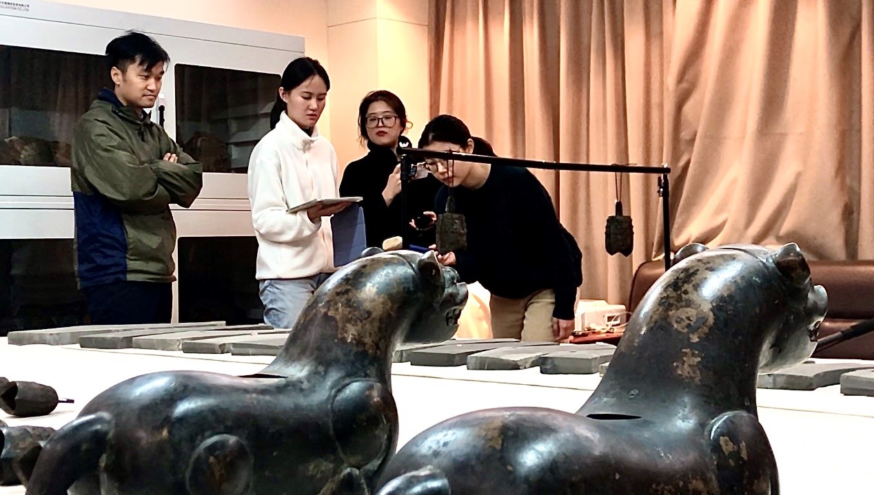 张闻捷教授和学生在对安徽武王墩出土编钟进行测音。