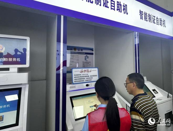 志愿者协助市民操作换证。人民网记者 张萌摄