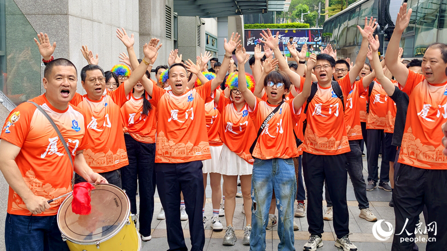 球迷们擂鼓欢呼，为出征队员加油打气。人民网记者 陈博摄