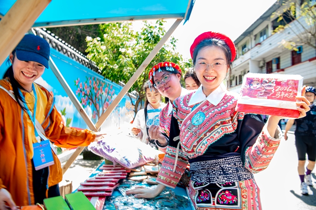 畲家姑娘在文创市集体验购物乐趣。杨柳州摄