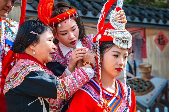 畲族特色表演家人为出嫁女儿梳妆打扮。杨柳州摄