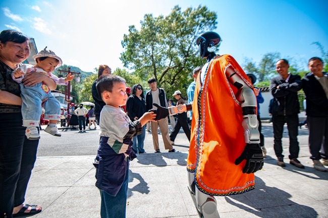 身着民族服饰的机器人与游客互动。杨柳州摄