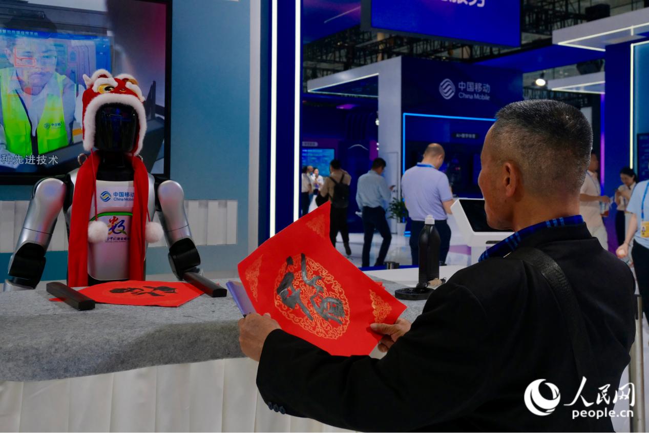 观众仔细端详中国移动展位上机器人写的“福”字。人民网 欧阳奕奕摄