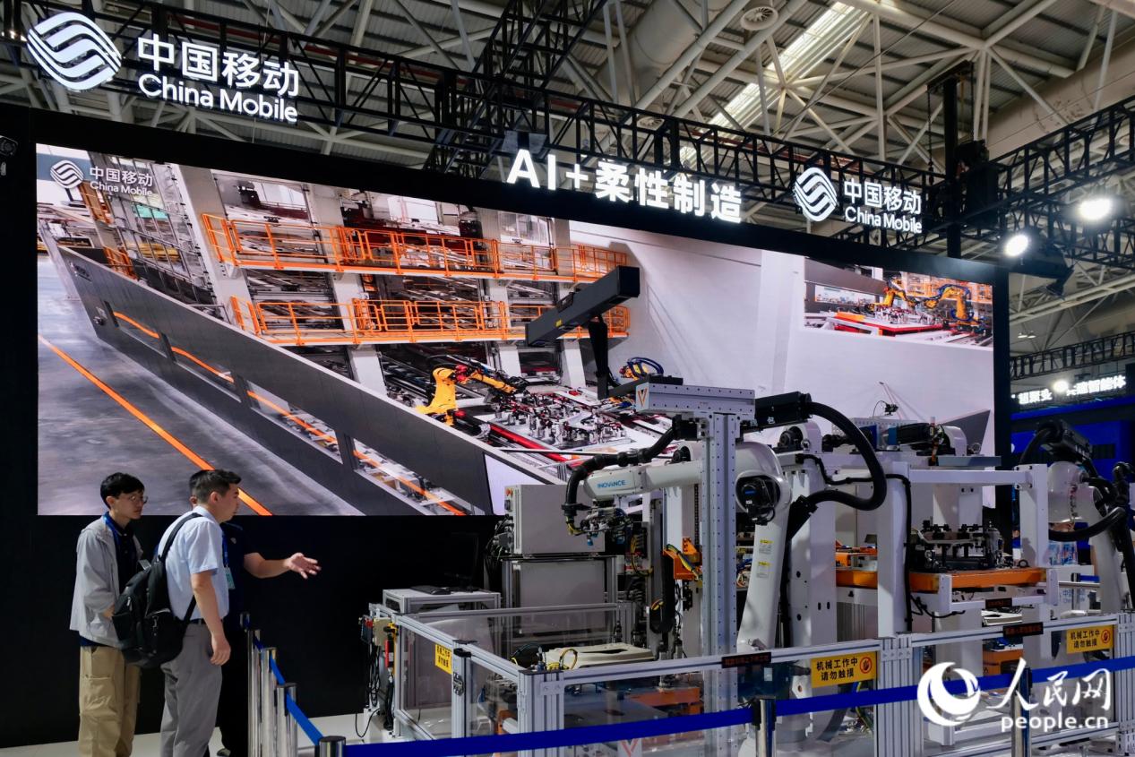 工作人员为观众介绍“AI+柔性制造”生产线。人民网 欧阳奕奕摄