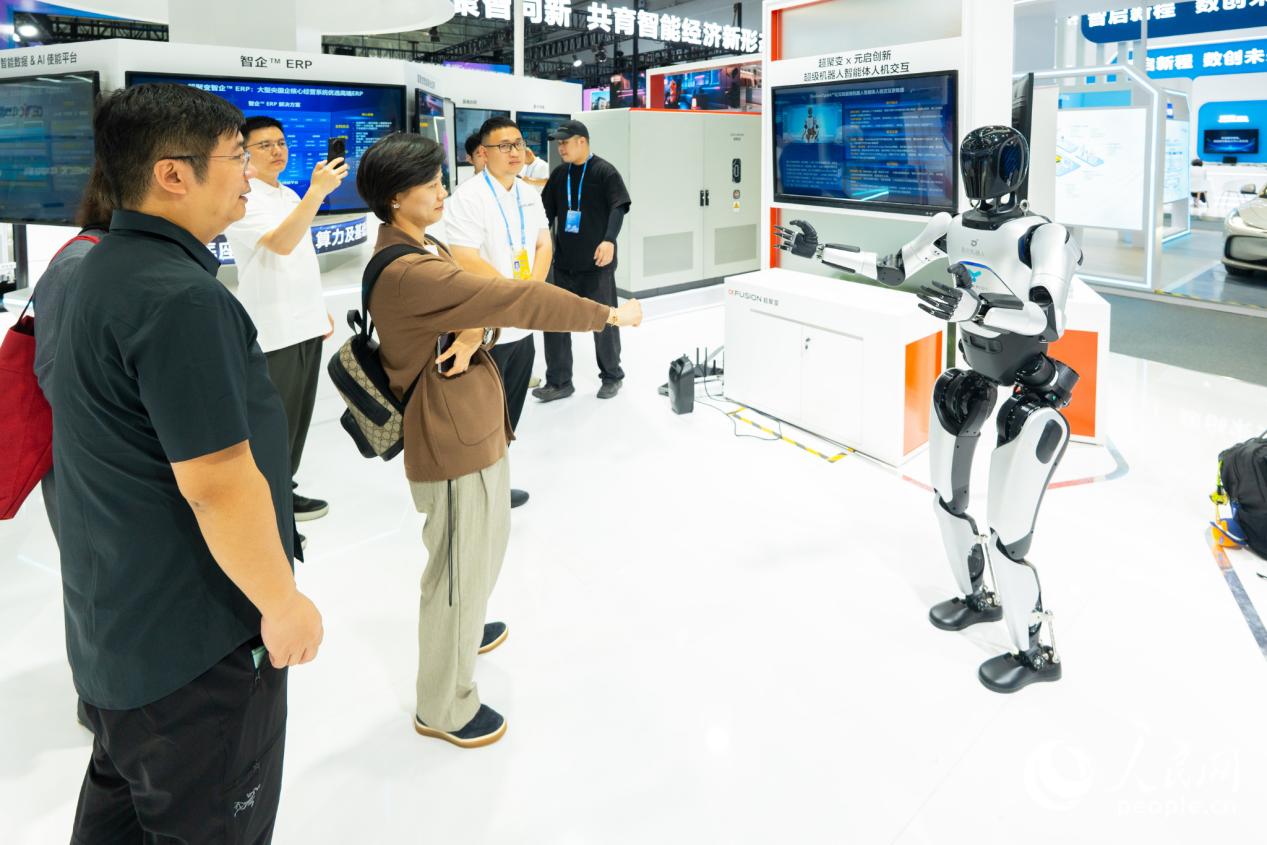 观众与机器人进行“石头剪刀布”游戏。实习生 李雨泽摄