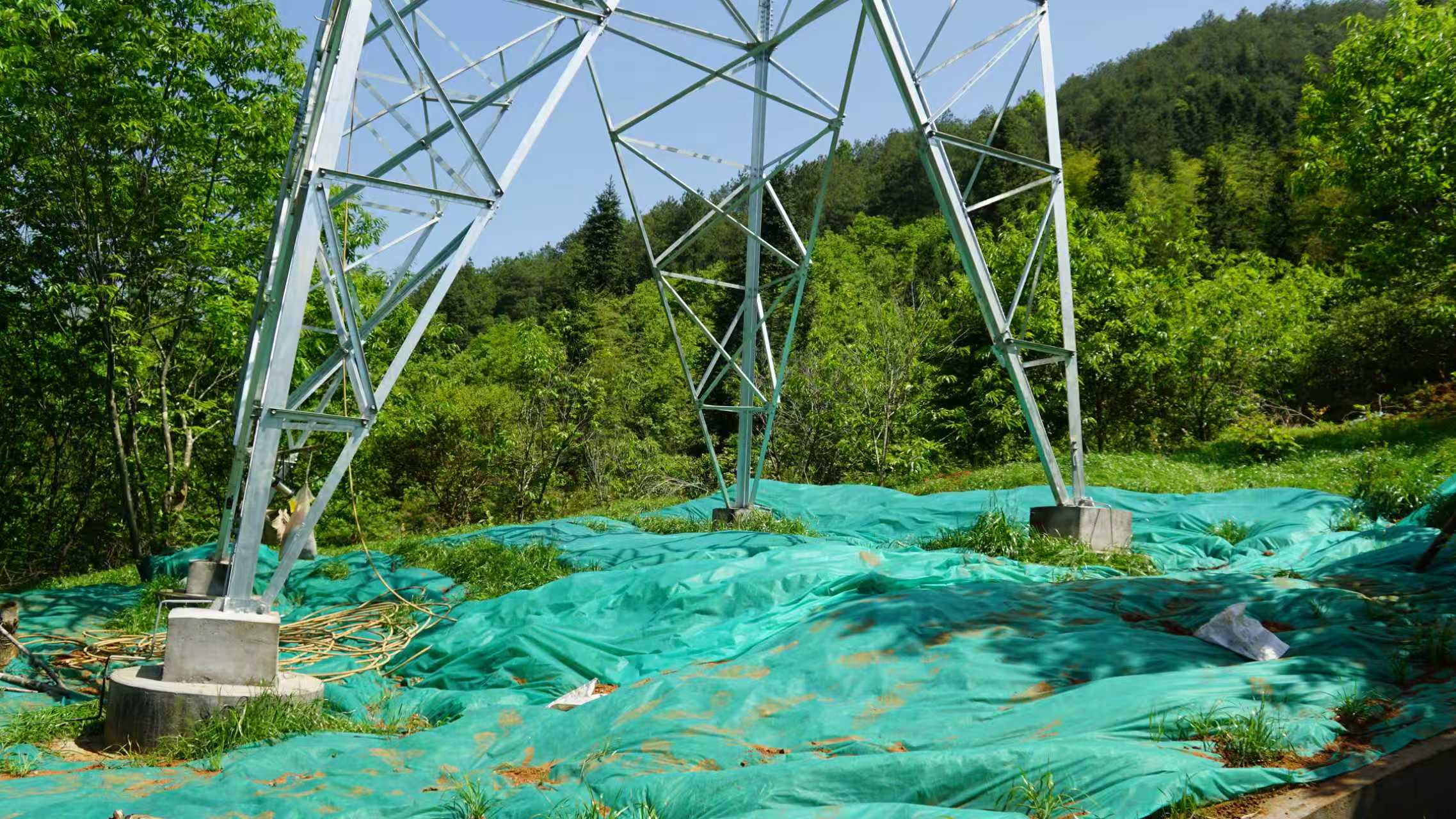 載重無人機正在往塔基附近投放草籽肥料