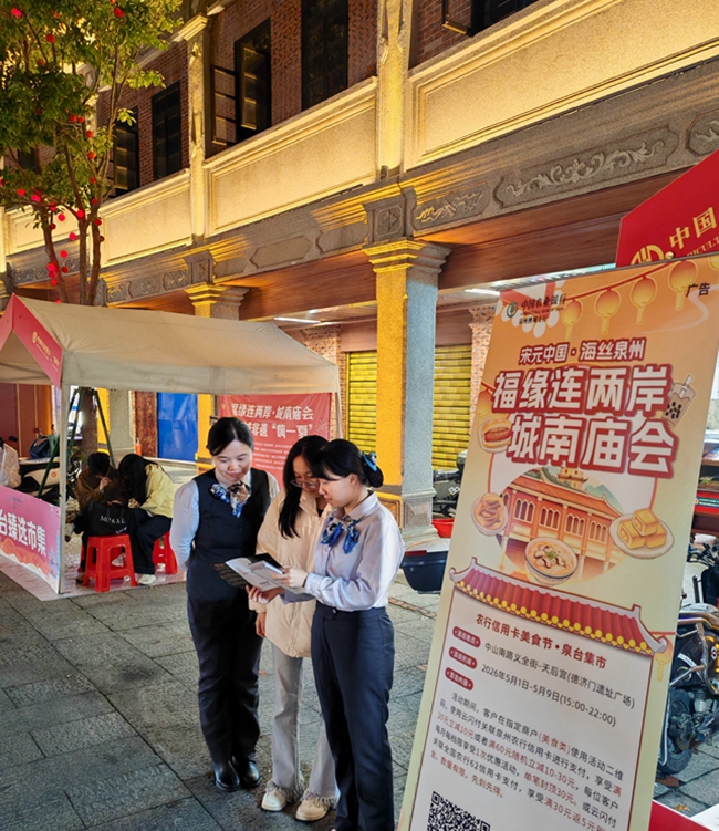 農行客戶經理向游客介紹農行信用卡消費活動。