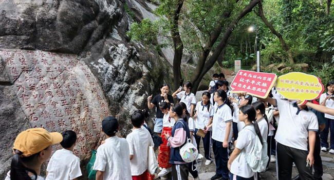 學校學生在九日山聆聽講解員解讀祈風石刻