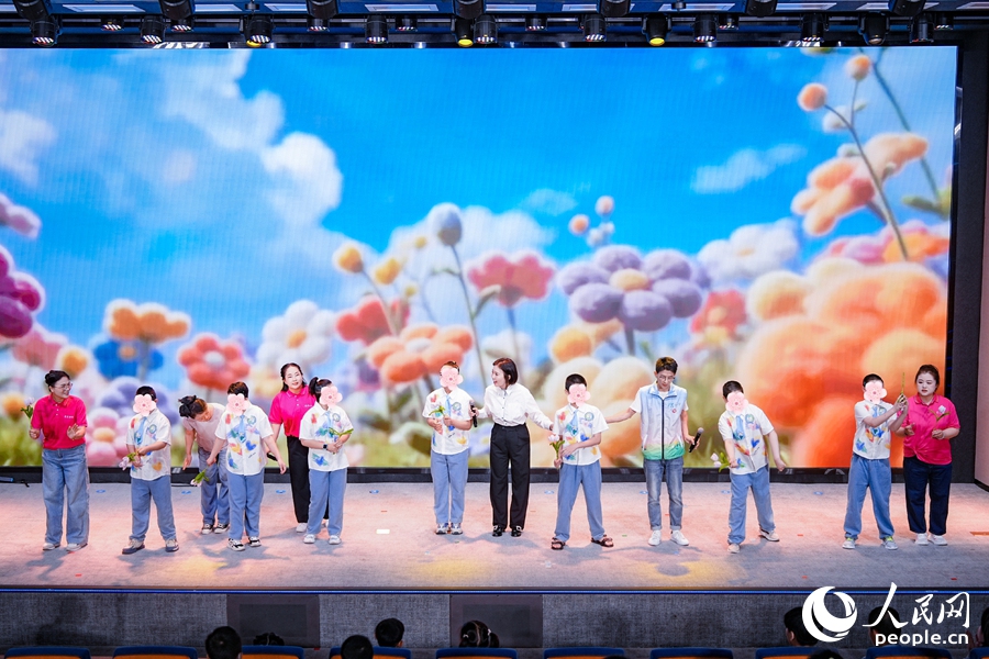 孤独症孩子们带着他们亲手制作的手工花现场表演《你笑起来真好看》，纯粹的笑容治愈全场。人民网摄