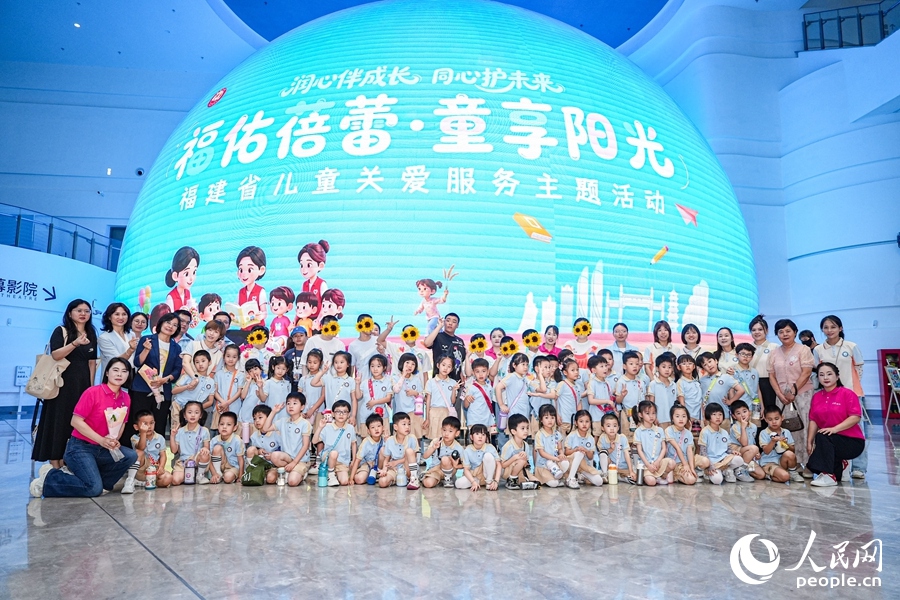 孩子们在活动主题球形屏前合影留念。人民网摄