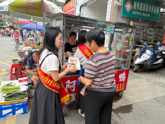 宣传人员走街串巷，跃在市场摊位与社区楼栋之间