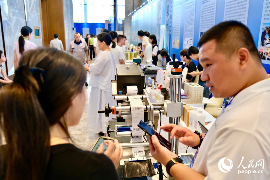 大赛成果交流展区内，参展创业者与参观者达成业务共识，互留联系方式对接合作。人民网 欧阳奕奕摄