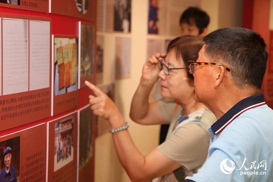 观众驻足展板前，俯身品读文字、轻声交流感悟。人民网记者 陈博摄