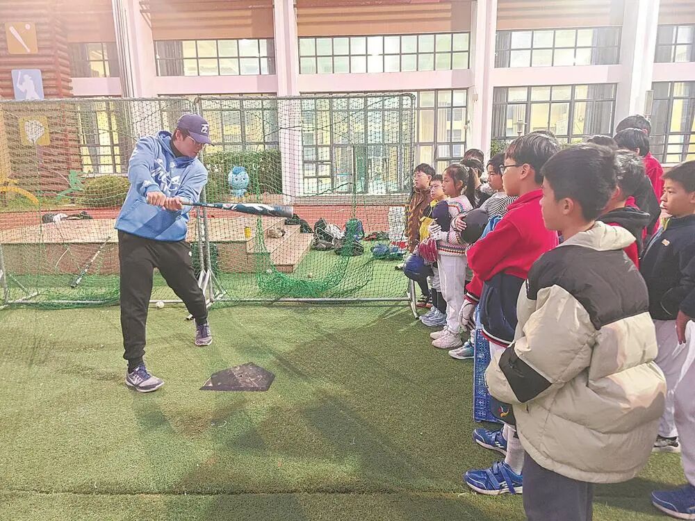 台湾棒球教练董士豪在福州马尾魁岐小学指导学生打棒球。福建省体育局供图