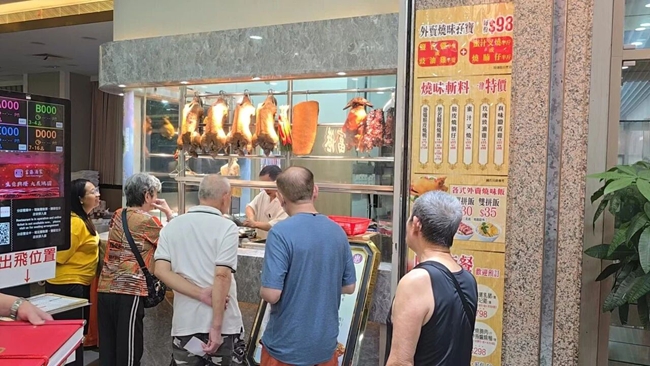 酒楼橱窗前,香港居民排队购买卤鹅