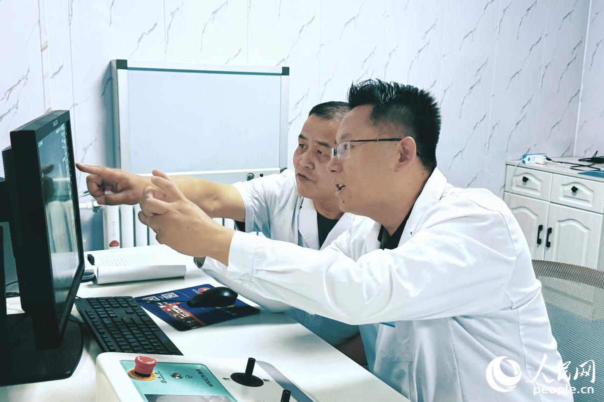 援宁医生郑鹏翔(右一)与当地医生交流业务。人民网记者 李唯一摄