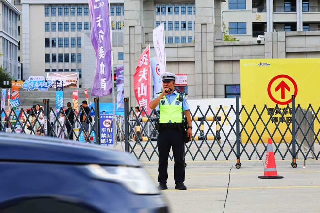 长汀县公安局交管大队大队长谢小先在长汀万人体育场前指挥交通。林丽莎摄