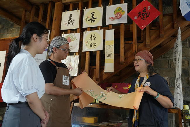 “崇仁丹露”茶饮店主理人陈彩云正在讲解手绘茶席的创作巧思与美学内涵。傅俊杰摄