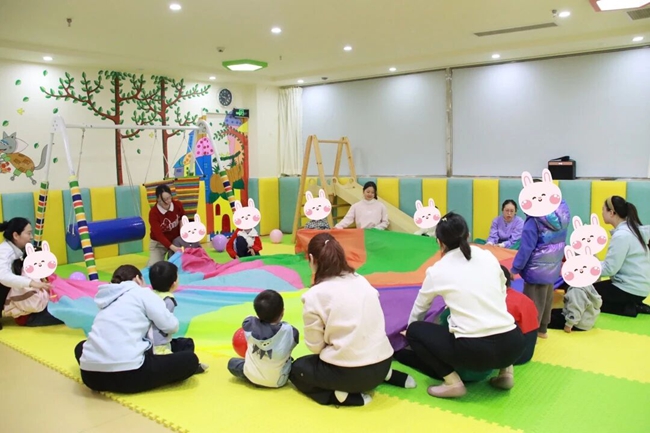 在亲子互动活动中，妇幼保健院医务人员与教师团队通过合作接力、角色扮演等社交游戏，引导孩子们在游戏中学会交流与表达。吴翠华摄