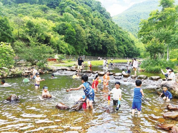 游客在九阜山旅游景区内戏水
