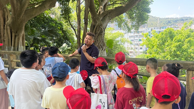 洪海樵向孩子们讲解摩崖石刻上的文字及背后的故事。思明区融媒体中心供图