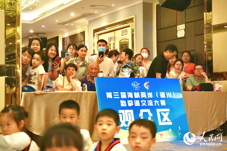 家长在观众区观赛，记录精彩瞬间。人民网 欧阳奕奕摄
