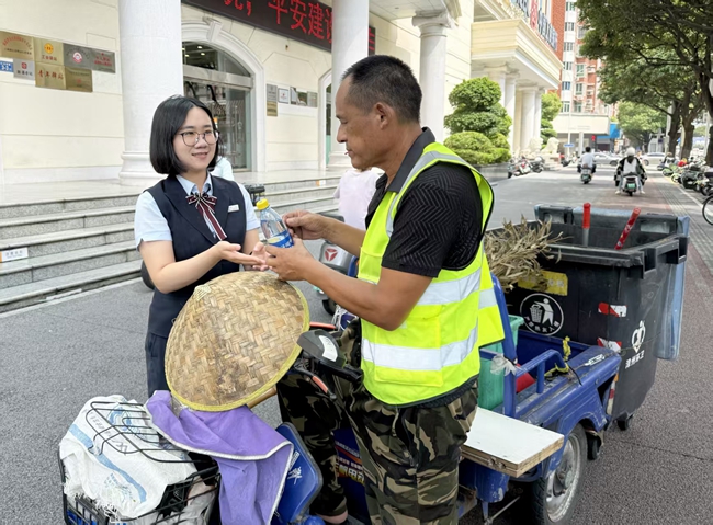 营业部工作人员向环卫工人送上饮用水