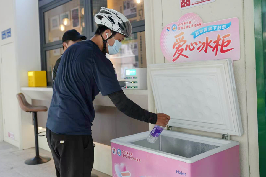 外卖骑手在滨中社区的“爱心冰柜”取水。彭菲摄