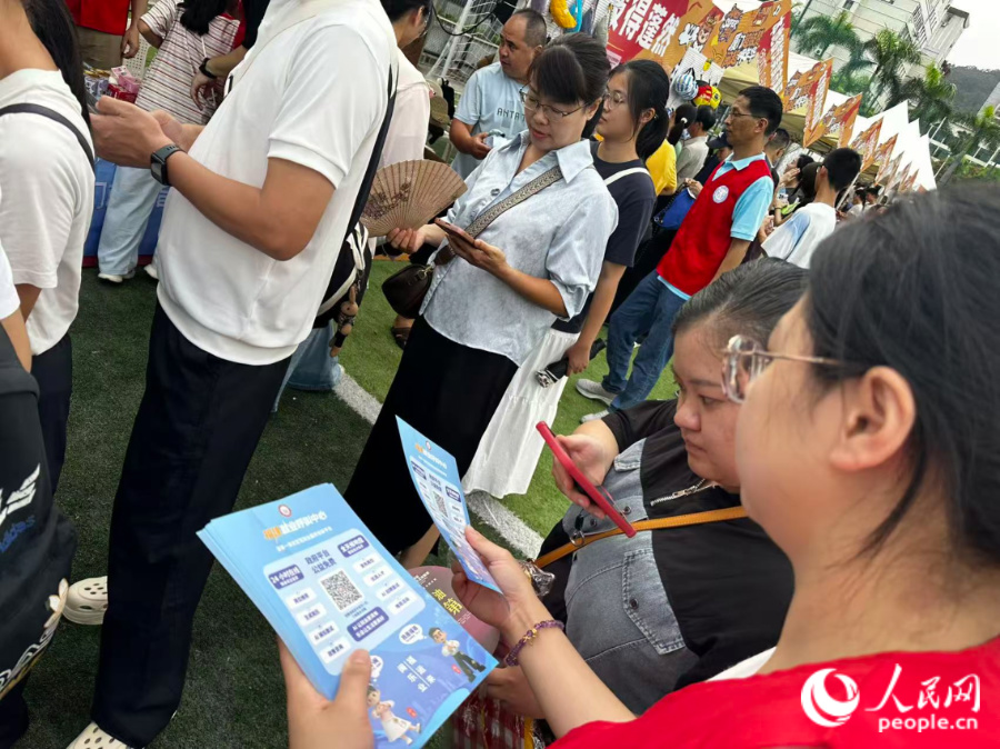 工作人员发放宣传材料。人民网记者 张萌摄