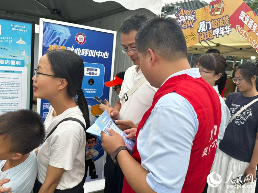 工作人员正在向市民介绍就业服务。人民网记者 张萌摄