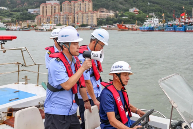 执法人员向渔民喊话，提醒他们及时撤离