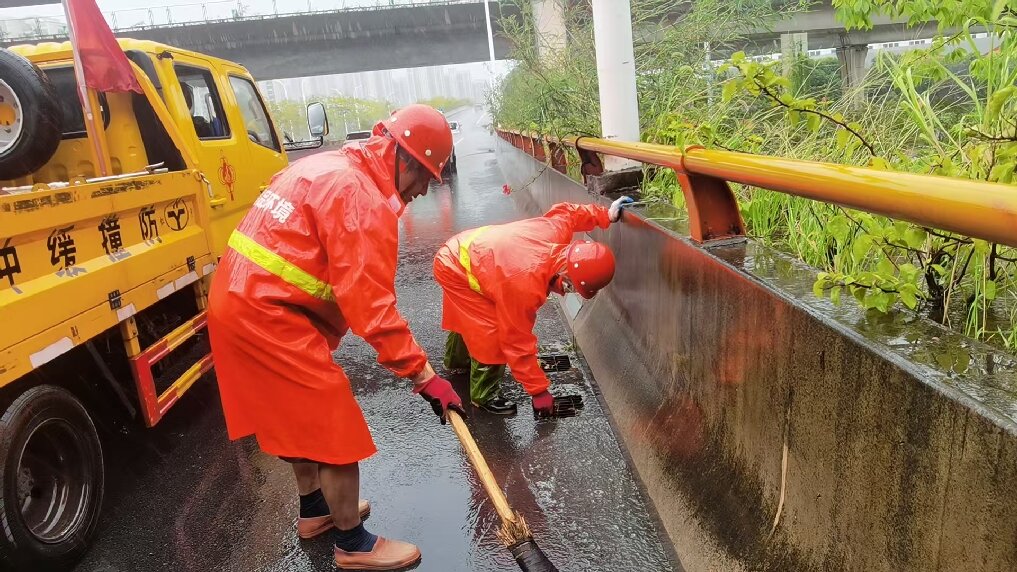 环卫人员清理道路排水口杂物。福州市城管委供图