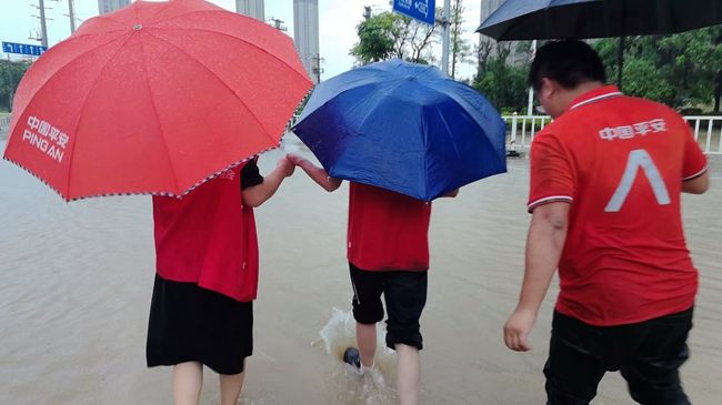 志愿者帮助学生通过积水路段