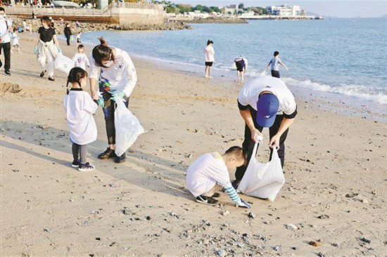 厦门马拉松蓝色公益发起“降塑不降速”公益亲子净滩活动，守护美丽海岸线。厦门市体育局供图
