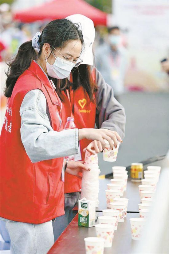 厦马赛道旁，文明志愿者为参赛选手提供志愿服务。厦门市委文明办供图