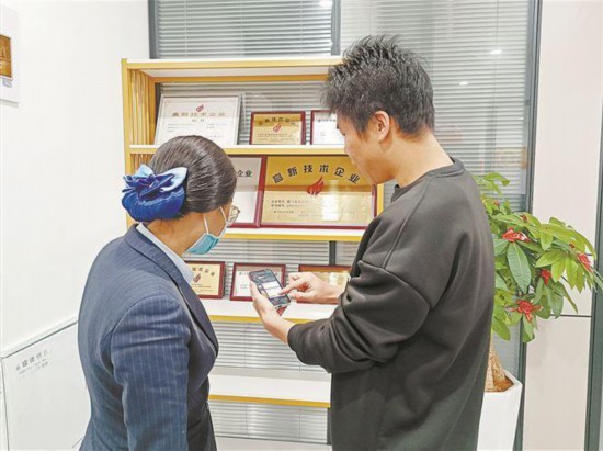 厦门建行客户经理走访高新技术企业，协助客户使用掌上银行便捷办理业务。厦门建行供图